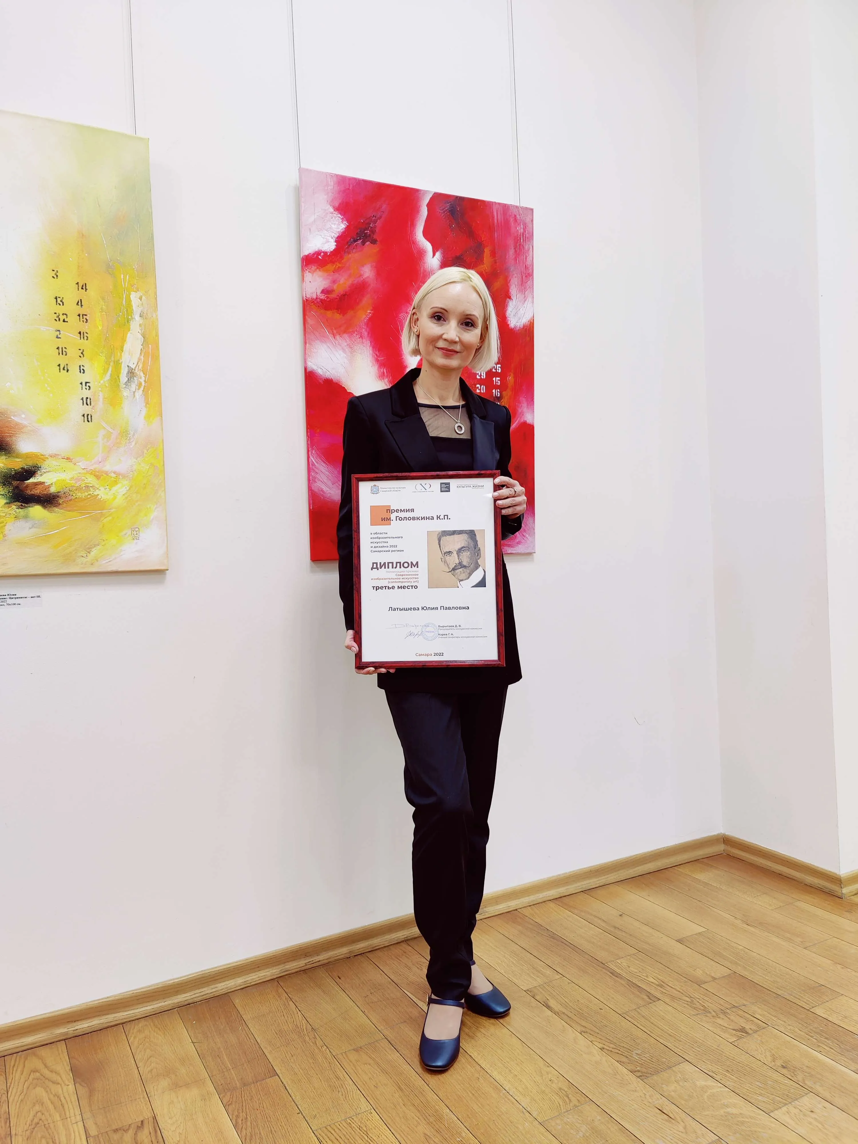 Юлия Латышева держит диплом лауреата премии им. Головкина, номинация 'Современное изобразительное искусство'