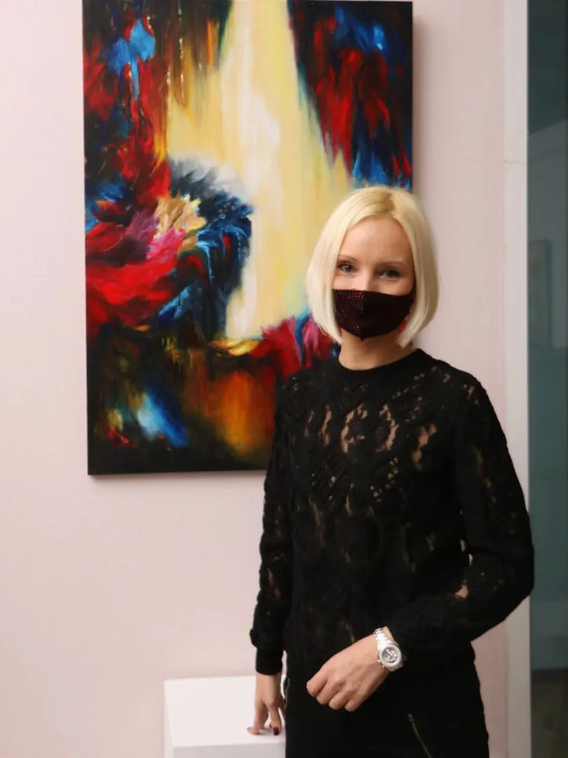 Юлия Латышева на фоне ее картины 'Тайное место' в выставочном пространстве ТСХР, Самара, Россия