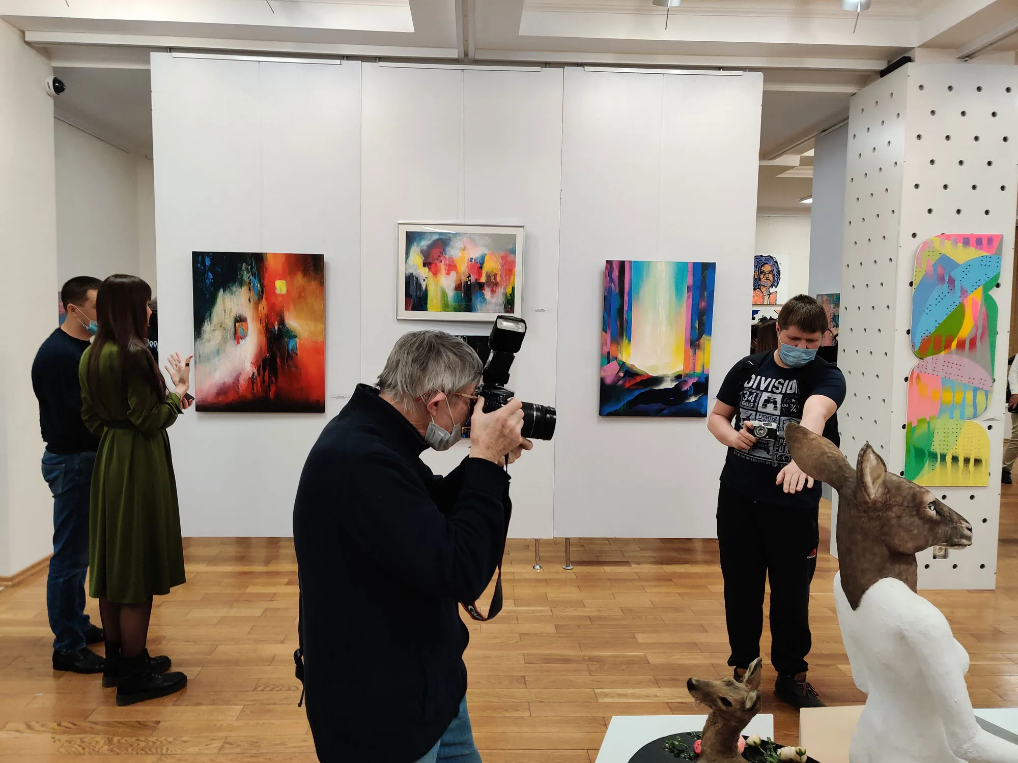 Photographers take pictures of an art object against the backdrop of paintings by Yulia Latysheva in the New Space gallery, Samara, Russia