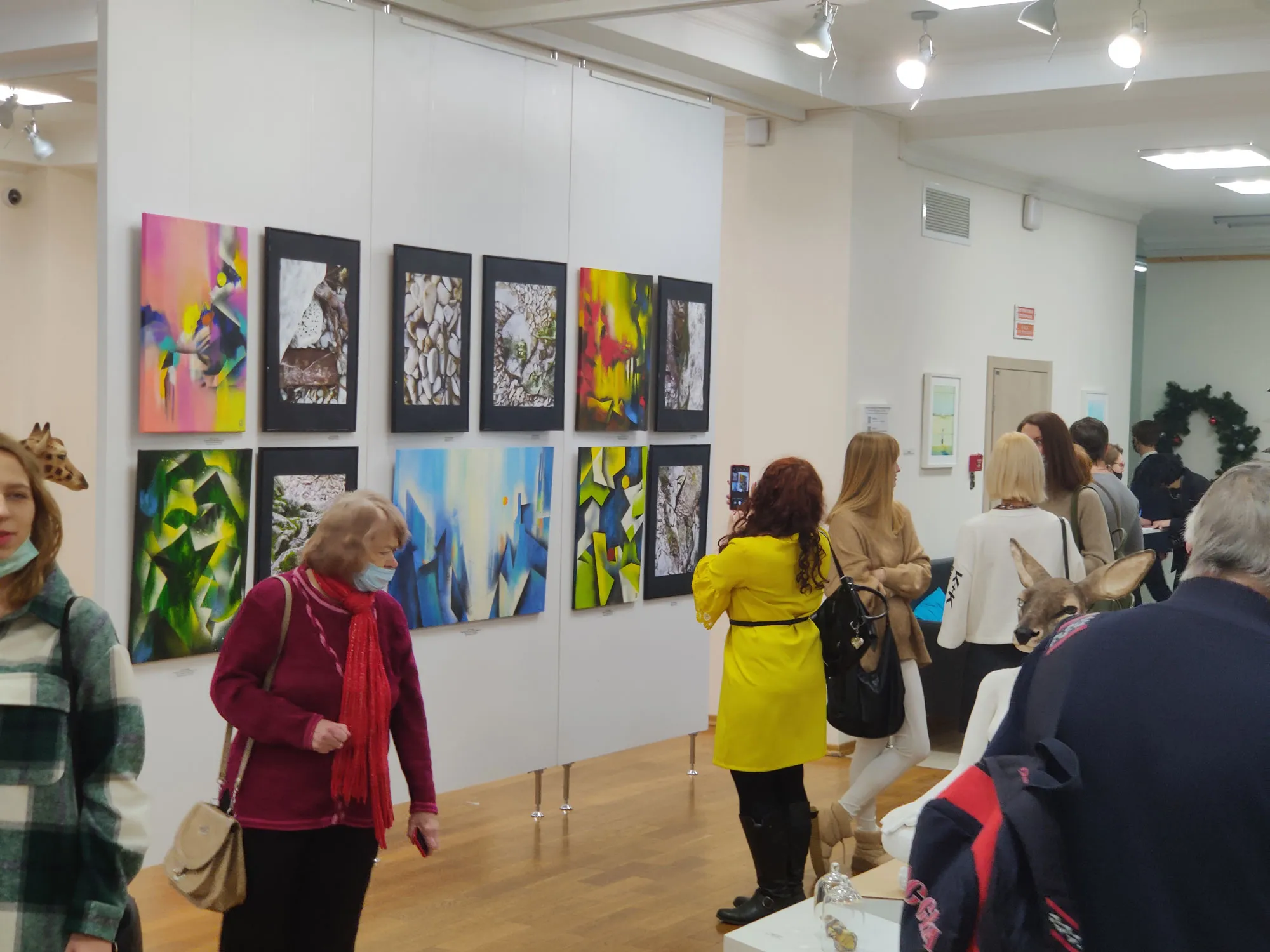 Spectators photograph paintings at the 'Against the Current' exhibition at the New Space gallery, Samara, Russia