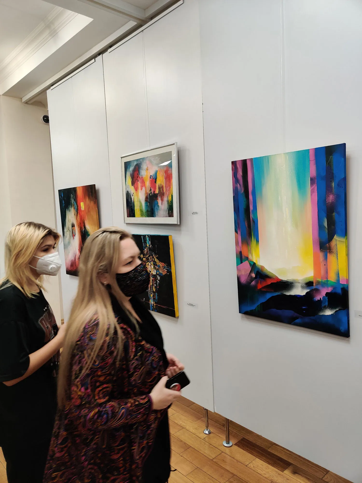 Viewers next to Yulia Latysheva painting 'Unforgettable' in the New Space gallery, Samara, Russia